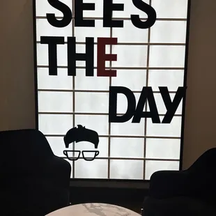 a coffee table and chairs in front of a window that says sees the day