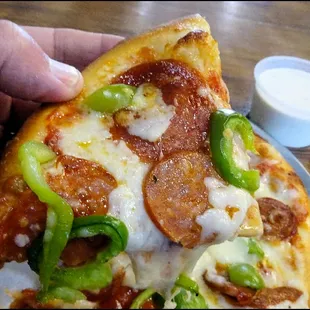 One piece of the pizza showing all of the goodness, including the melted cheese, fresh bell pepper, pepperoni slices and linguica.  Yes!