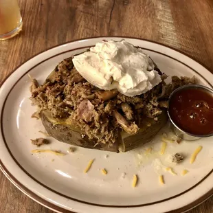 BBQ pork baked potato with cheese, sour cream and sweet bbq sauce.