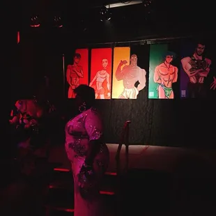 a woman standing in front of a group of paintings