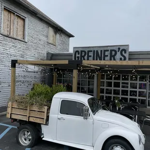 a white truck parked in front of a restaurant