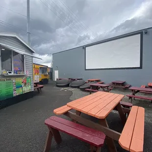 Picnic tables, outdoor seating, a projector movie screen