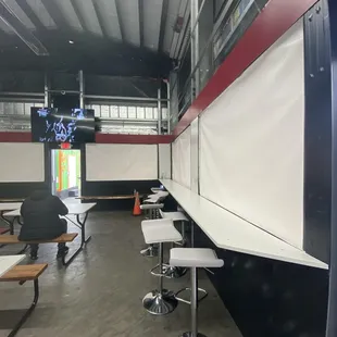 Interior seating and some TVs. Windows closed on this rainy day