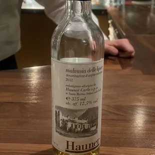 a bottle of white wine sitting on a bar