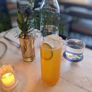 a glass of lemonade and a bottle of water on a table