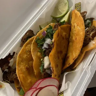 three tacos in a styrofoam container