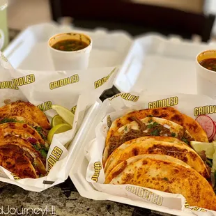 two trays of tacos and a drink