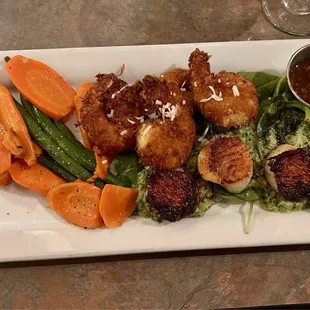 Daily special. Scallops &amp; coconut prawns on a bed of wilted spinach topped w/homemade pesto.