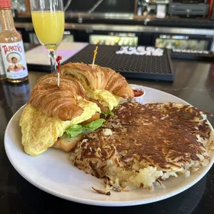 Croissant sandwich with hash browns.