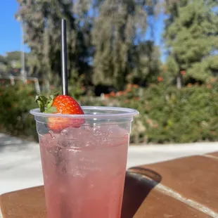 a strawberry drink in a plastic cup
