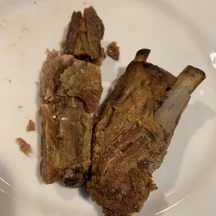 two pieces of meat on a white plate
