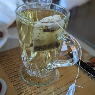 a glass of tea with a piece of cake in it