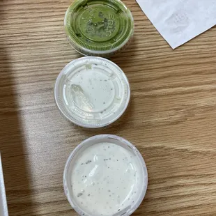 three containers of sauce on a table