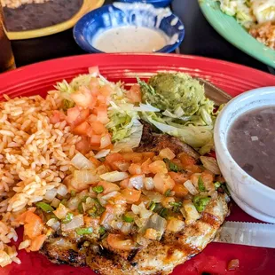 Grilled pork chop spiced perfectly with rice and black beans.