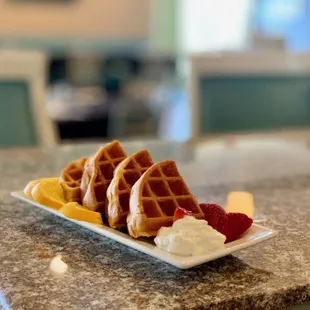 a plate of waffles and fruit