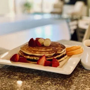 a plate of pancakes with strawberries and syrup
