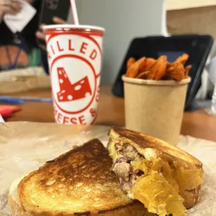 a woman taking a picture of a sandwich