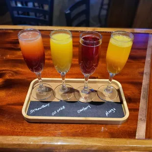 four glasses of juice on a serving tray