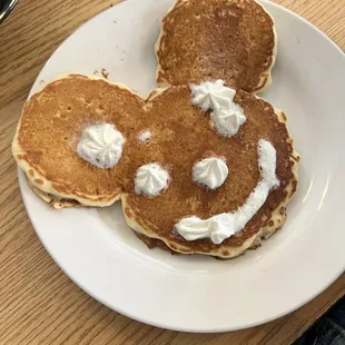 a plate of pancakes with whipped cream