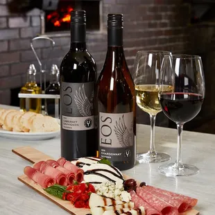 two bottles of wine and a cheese board