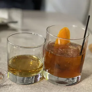 two glasses of drink on a table