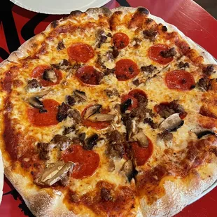House pizza with pepperoni, sausage and half mushrooms.
