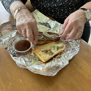 a woman cutting into a sandwich