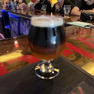 a glass of beer on a bar