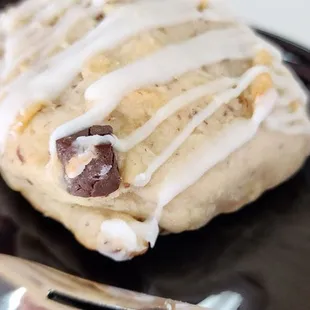 a chocolate chip cookie on a black plate with a fork