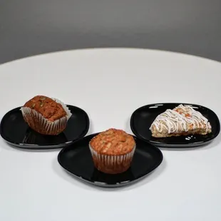 three muffins on black plates