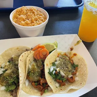 (Left to right) Carne on flour, al pastor on corn tortillas. Side of rice. Mango margarita.