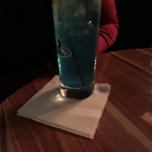 a blue drink on a napkin