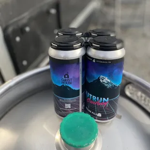 two cans of beer on a keg