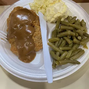 Country style steak with gravy, potato salad and green beans.