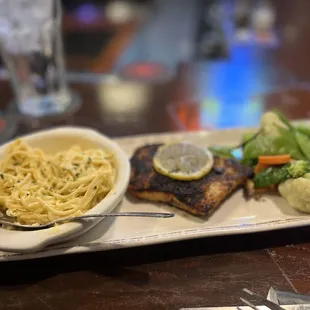 Wood fired salmon with veggies and angel hair pasta in a Parmesan cream sauce.