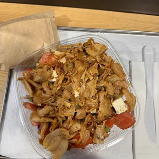 This is a Greek salad with chicken on it.