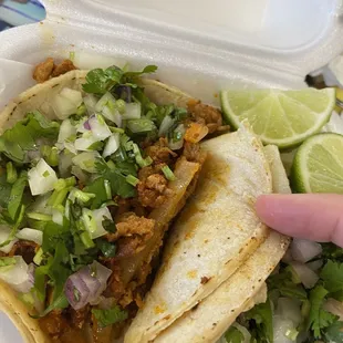 two tacos in a styrofoam container