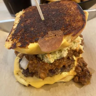 A great loaded burger, with inverted top bun, chili, slaw and bacon!! Terrific crisp fries hiding in the background.