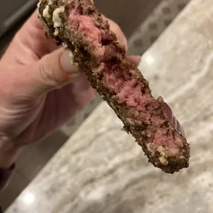 a hand holding a piece of meat