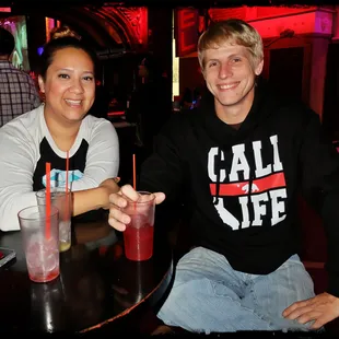 a man and a woman sitting at a table with drinks