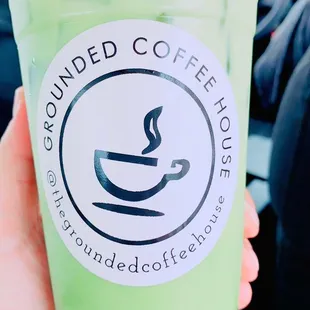 a hand holding a cup of iced coffee