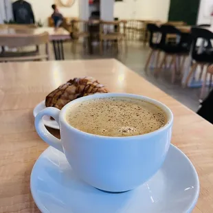 Eggnog latte with chocolate croissant in the background
