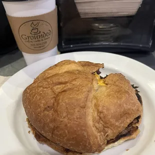 Croissant Breakfast Sandwich with bacon, egg &amp; green Chile with a mexicali coffee.