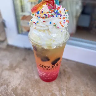 a cup of iced coffee with whipped cream and sprinkles