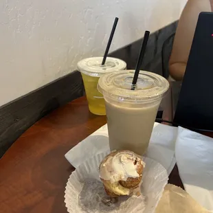 Seaside (mango) iced tea, sweetened Hammered French press coffee, iced, medium, &quot;sweet and creamy&quot; style  Cinnamon roll (half-eaten)