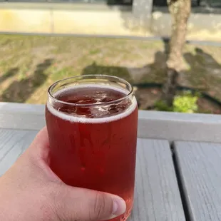 a hand holding a glass of beer