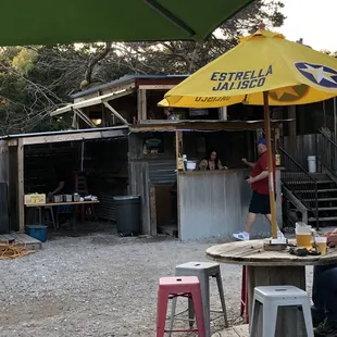 a man sitting at a table under an umbrella