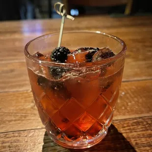 a glass of cocktail on a wooden table