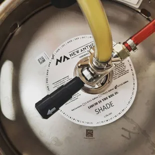 a keg with a yellow hose