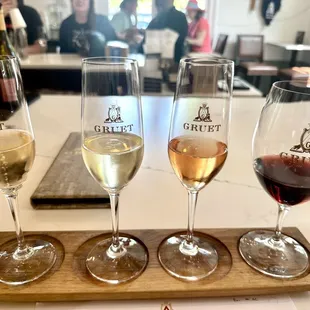 three glasses of wine on a wooden tray